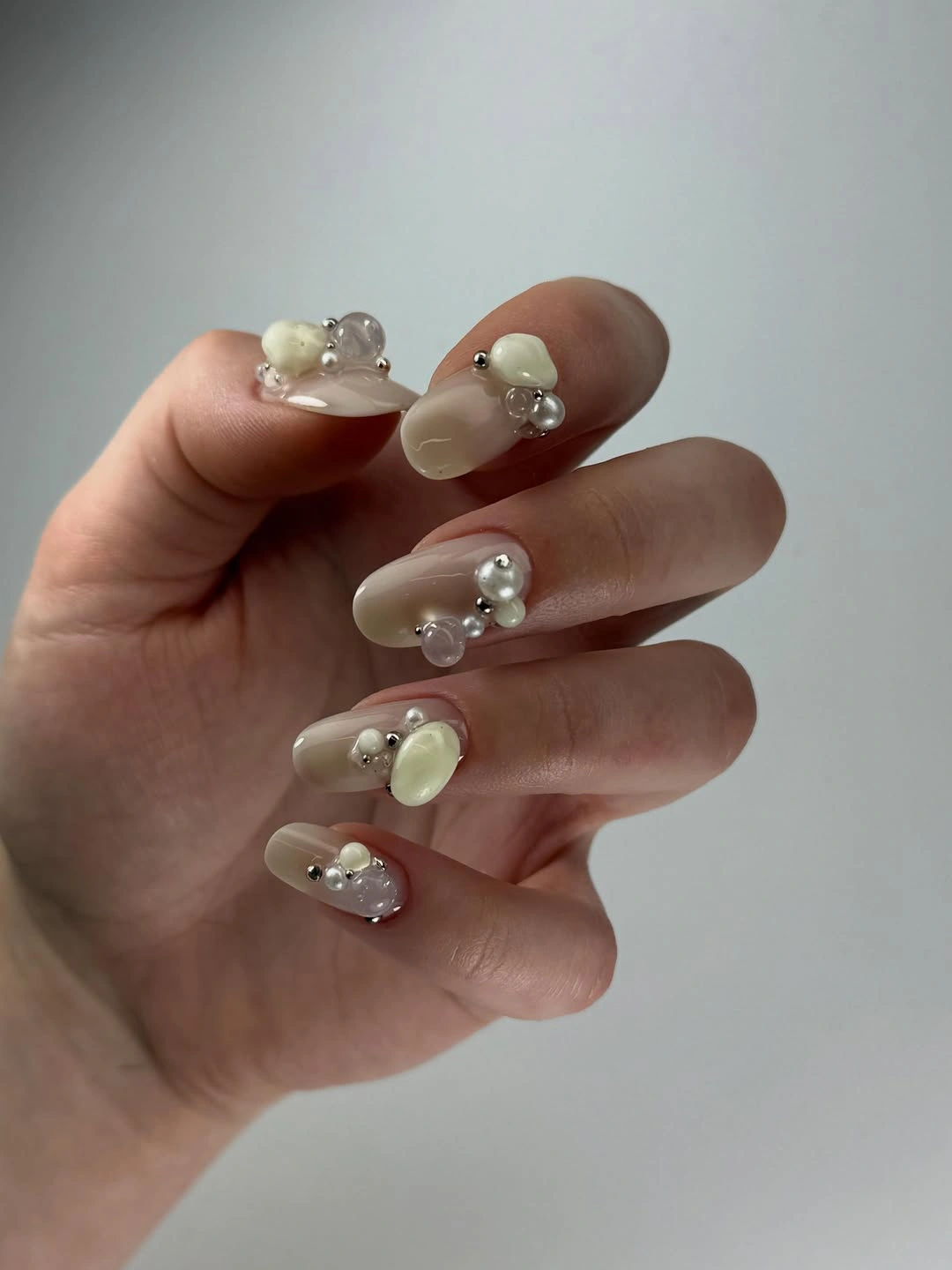 Long almond nails with raised pearl-like bead clusters