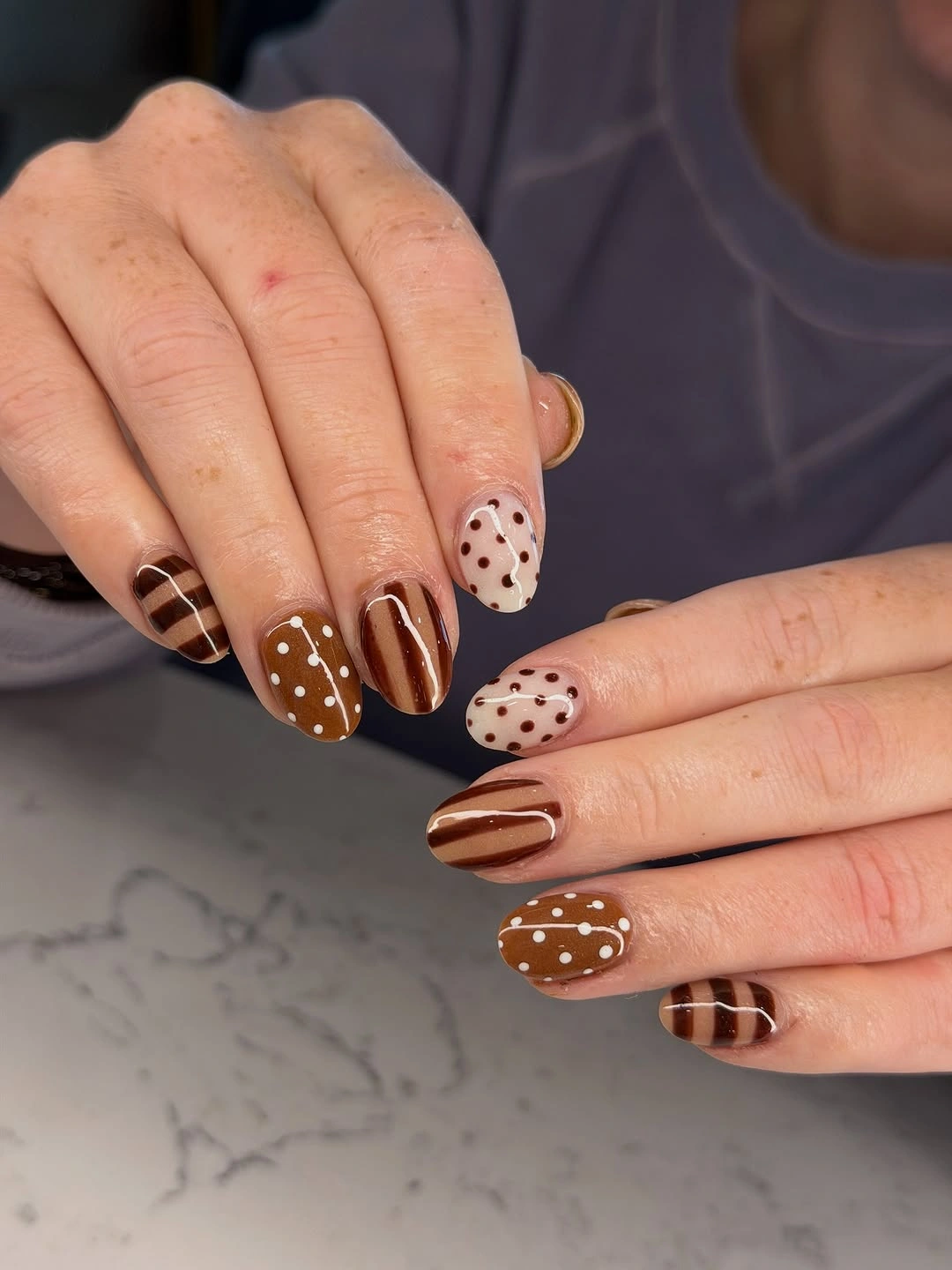 Caramel brown nails with white dots and striped accents