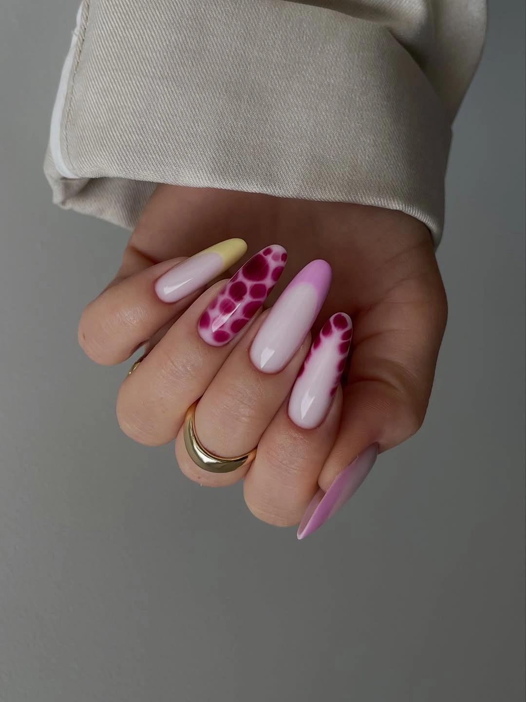Long pale pink nails with vivid magenta spotted accents