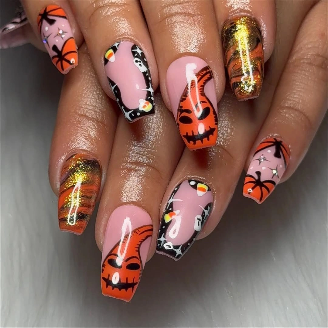 Almond nails with orange jack-o-lanterns bats and gold accents