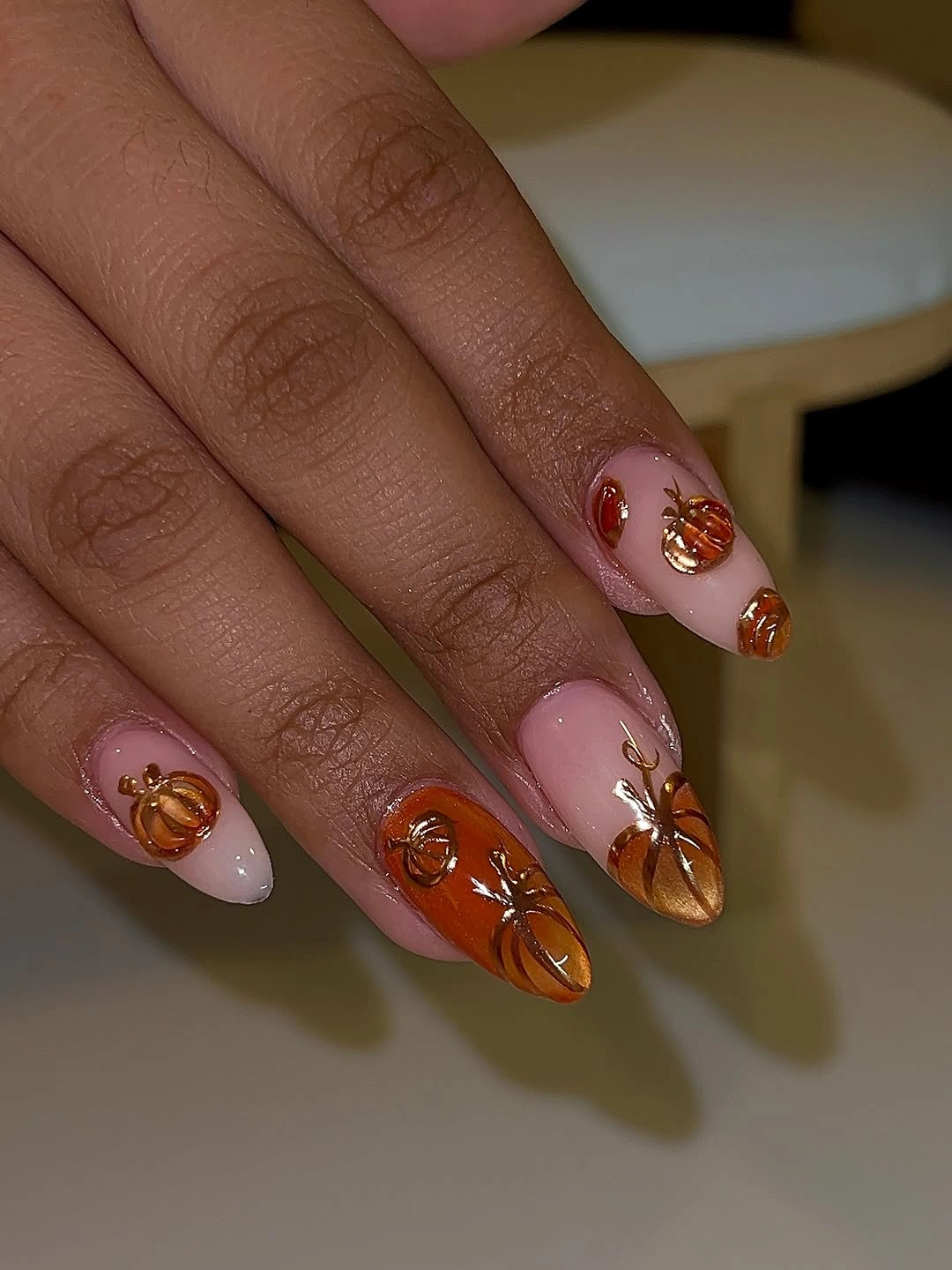 Blush almond nails with copper pumpkins and leaf details