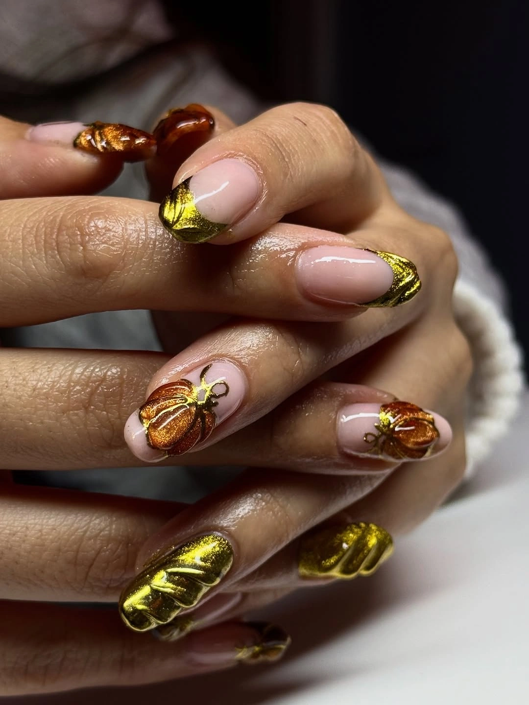 Neutral almond nails with reflective amber pumpkin details