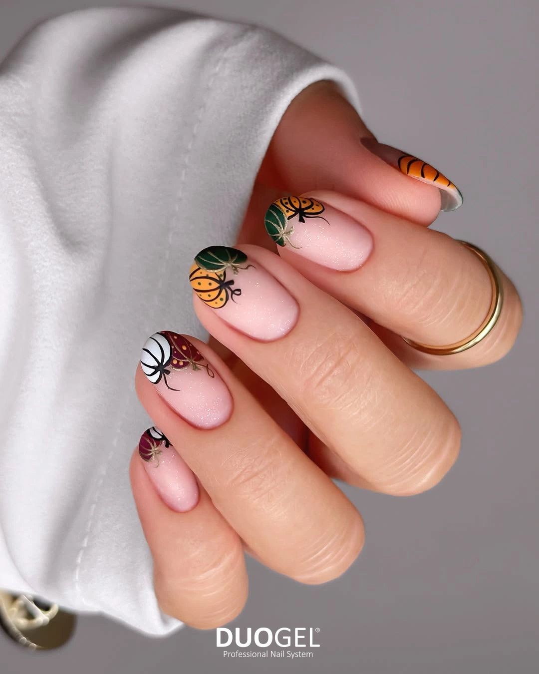 Short pink nails with tiny orange black Halloween characters