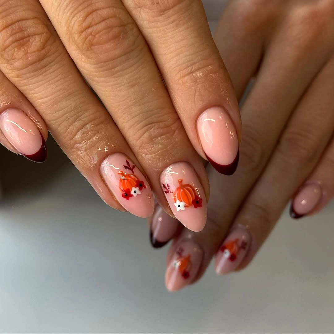 Sheer blush oval nails with tiny orange pumpkin details