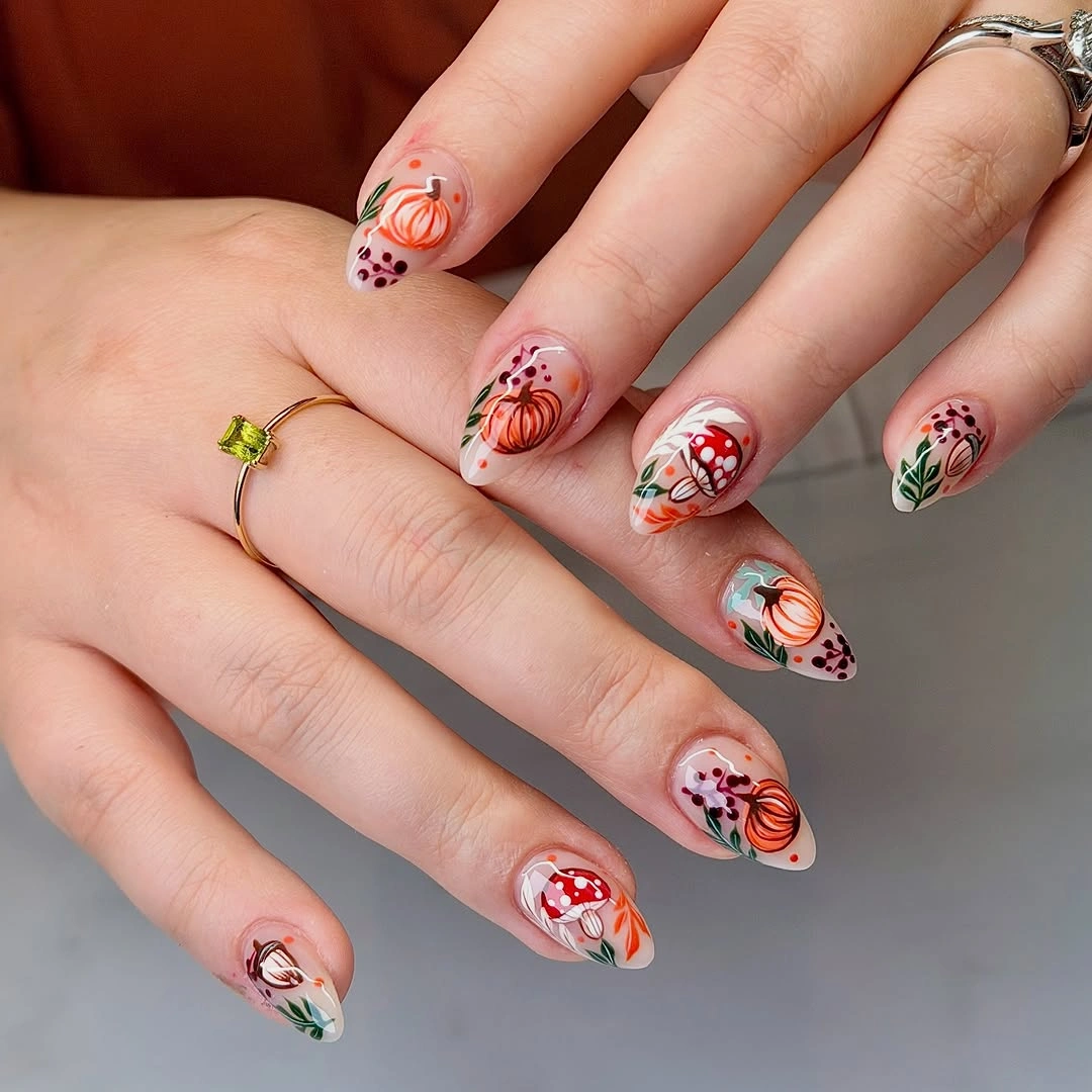 Long almond nails with orange pumpkins and leaf accents