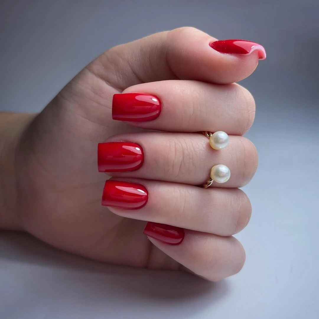 Glossy red square nails with pearl styling