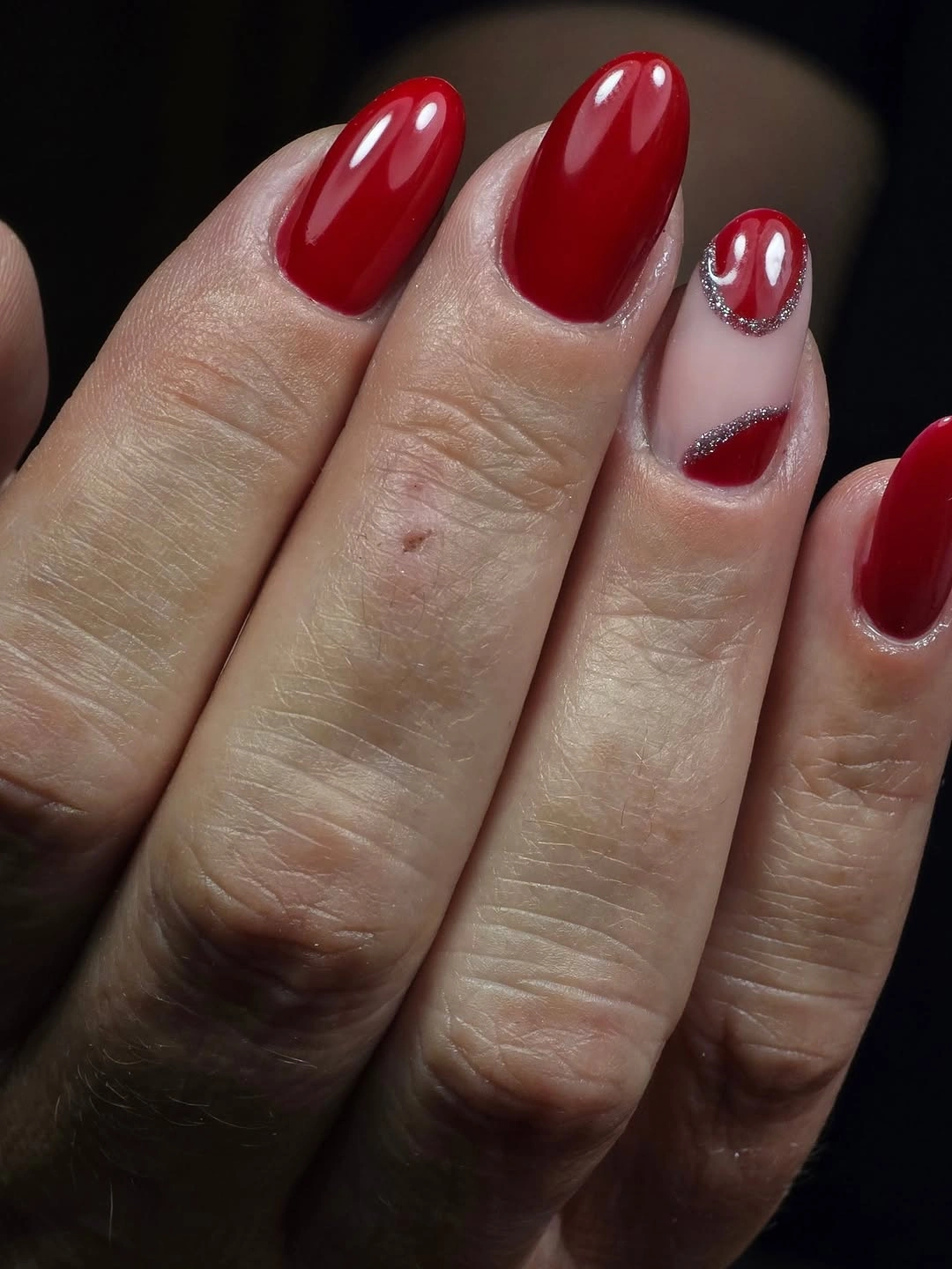 Red almond nails with glitter crescent accent