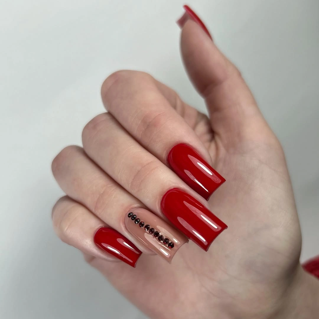 Long red square nails with jeweled accent