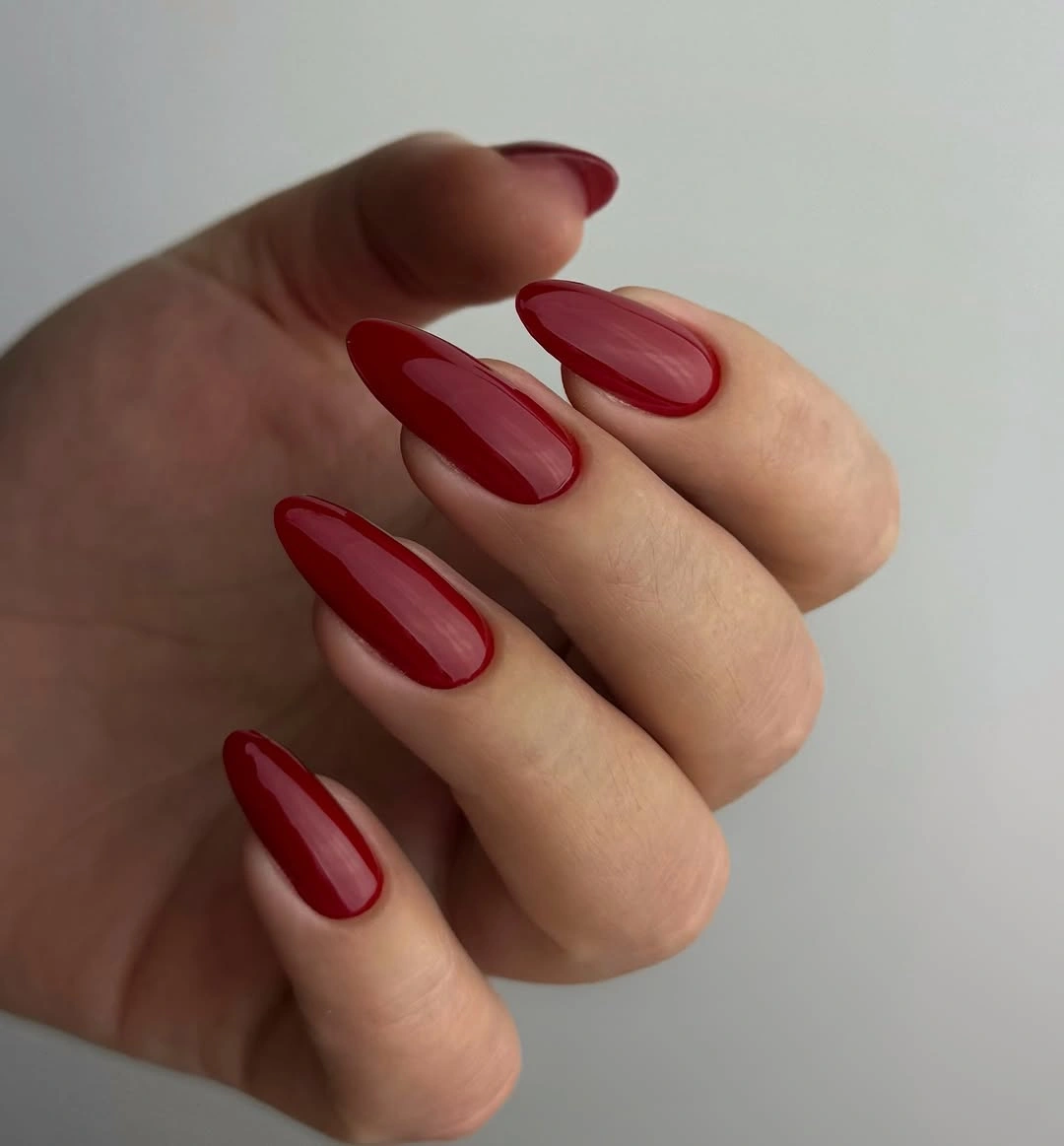 Sheer red almond nails with darker edges