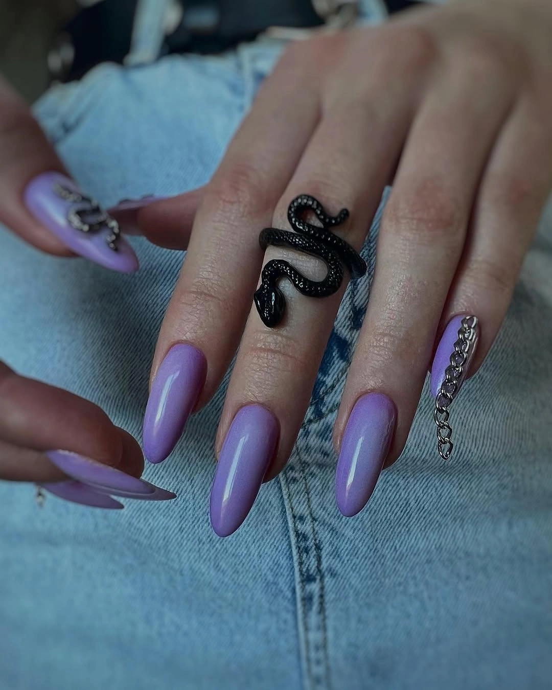 Lavender almond nails with a dark curved accent