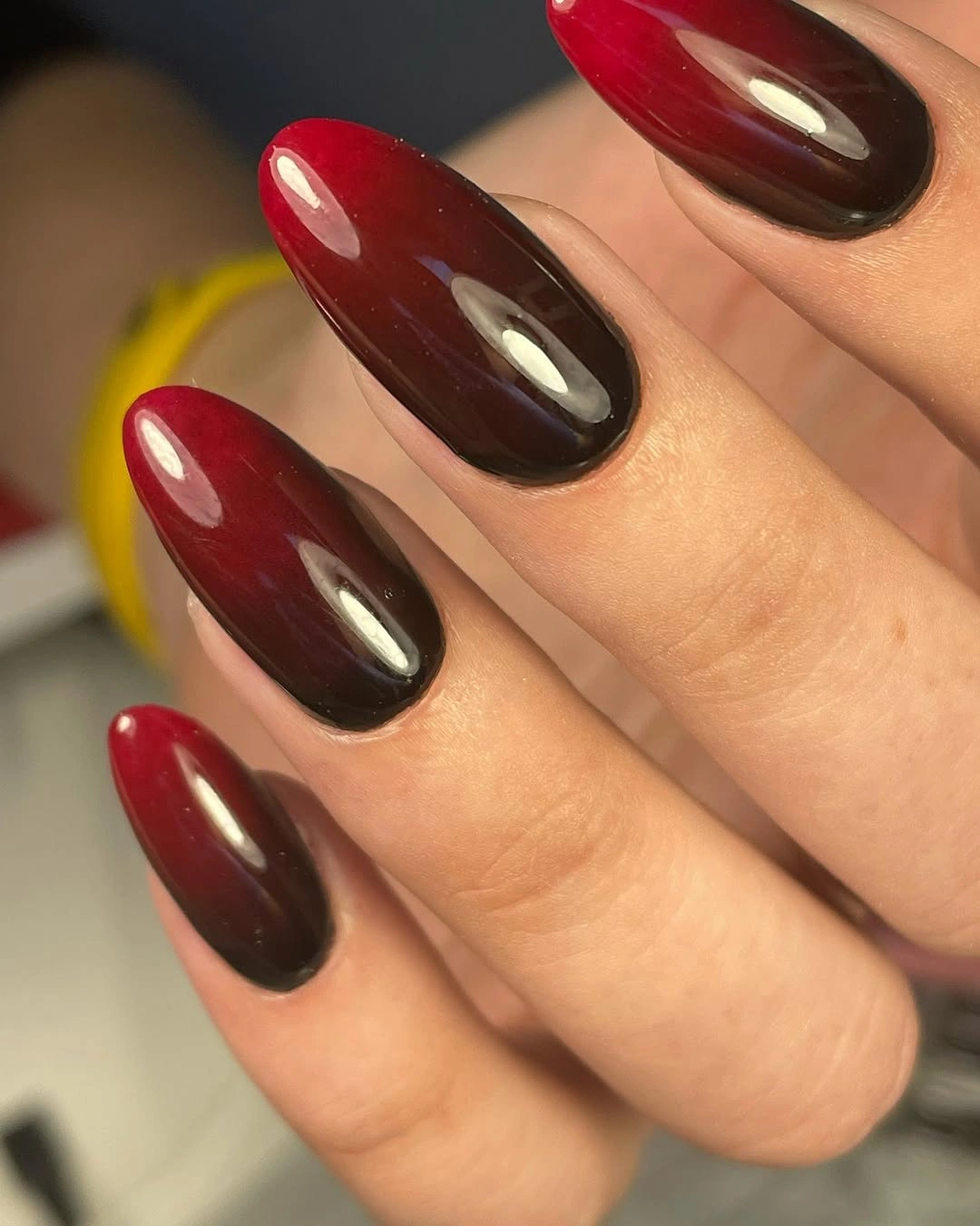 Glossy burgundy brown gradient on long almond nails