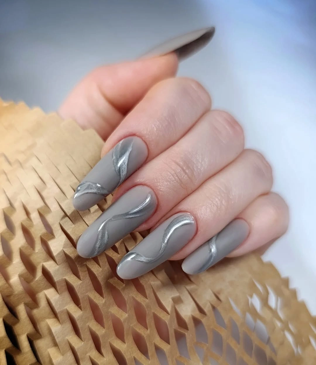 Cool gray almond nails with curved silver accents