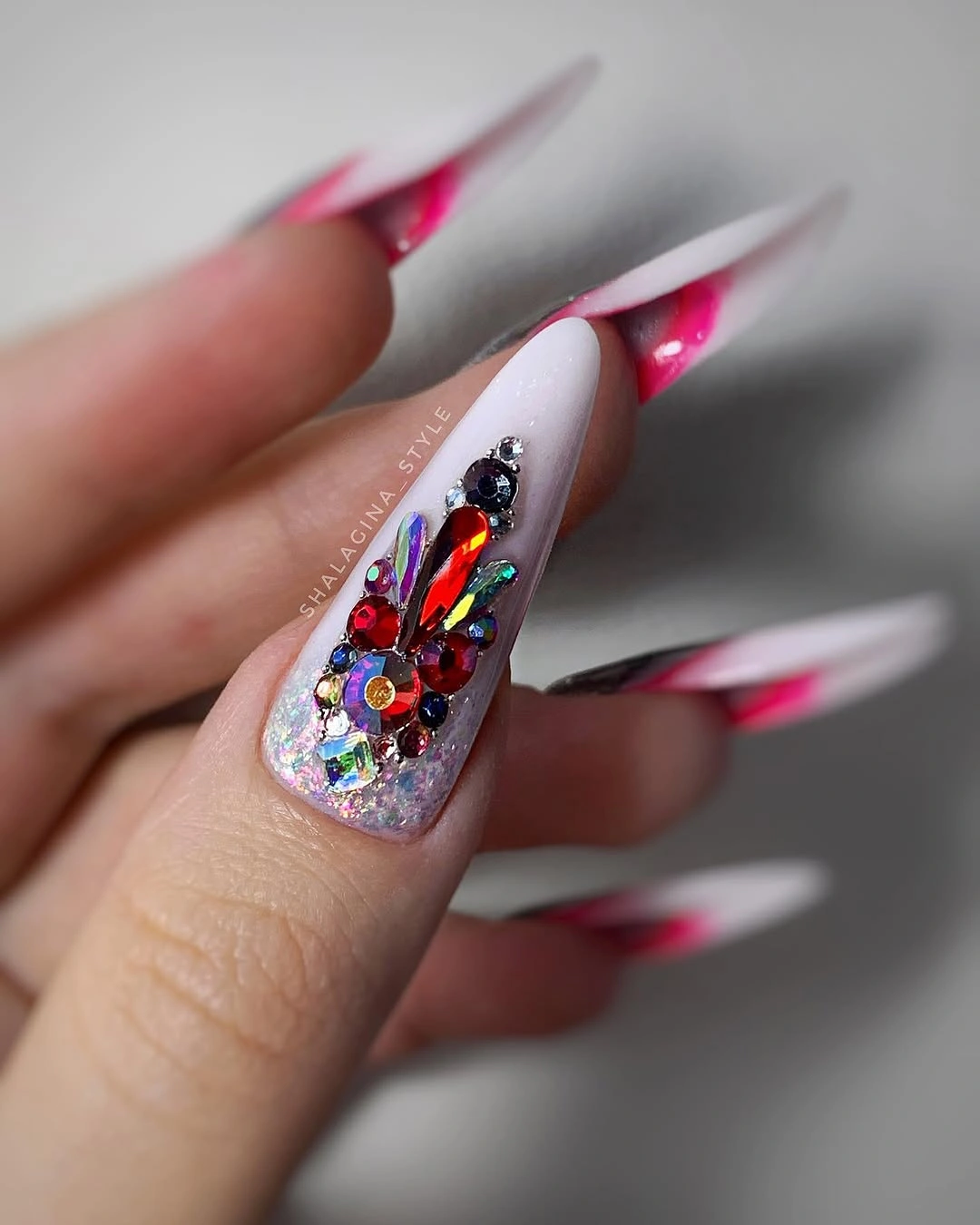 Pink pointed nails with one dense jeweled accent