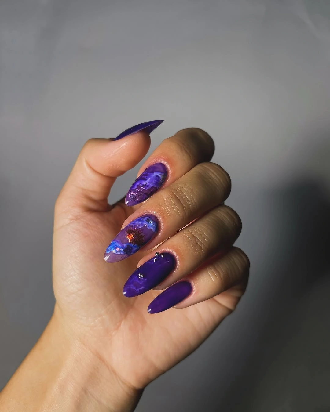 Deep purple almond nails with selective shimmer accents