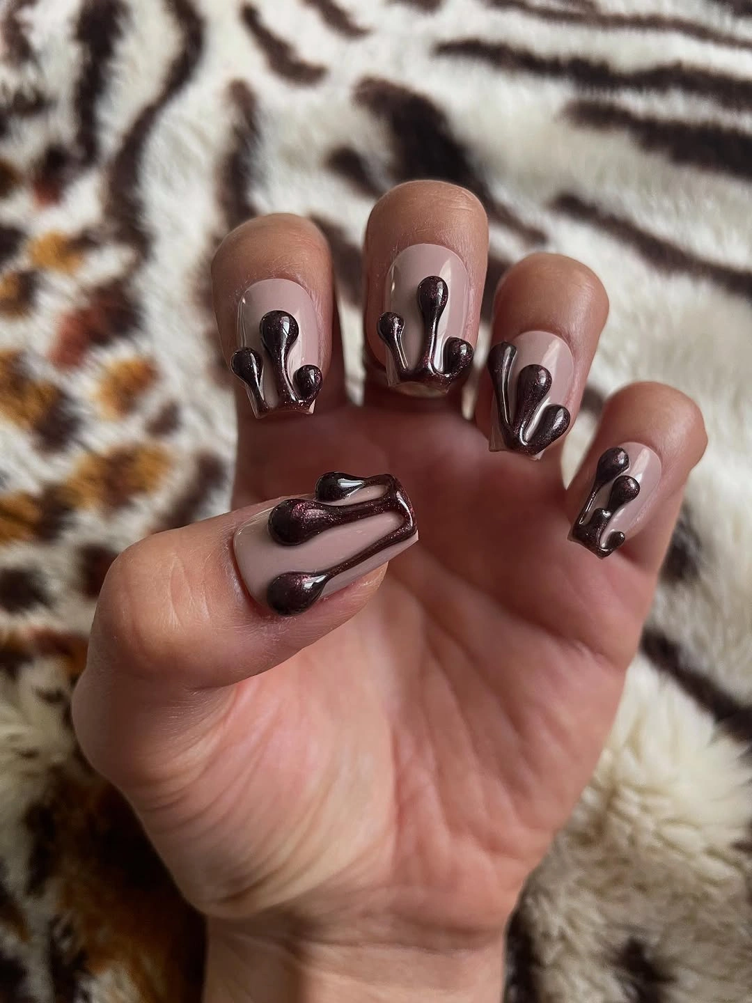 Short dark brown nails with curved sculptural-looking accents