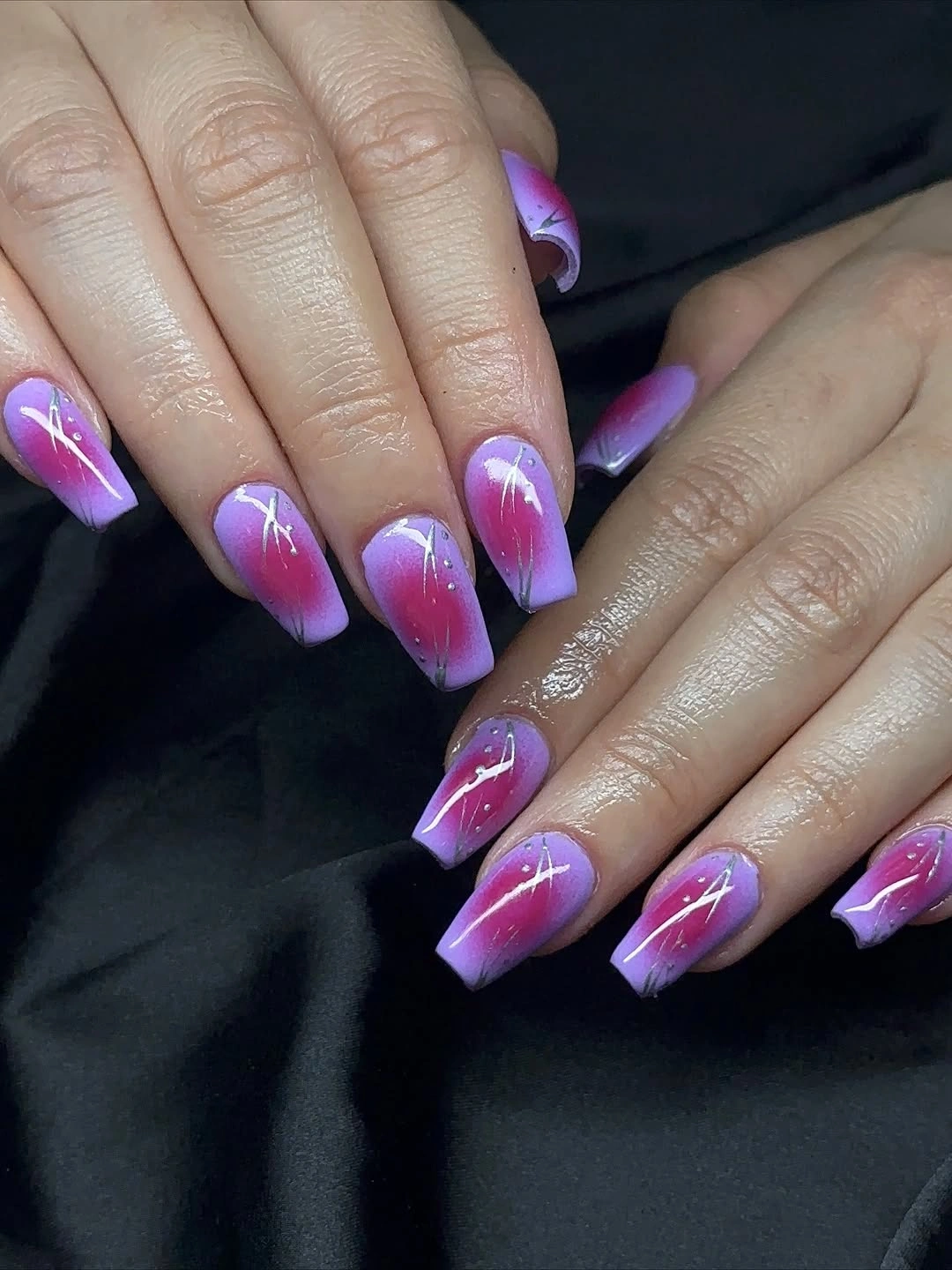 Short purple and pink nails with sweeping white curves