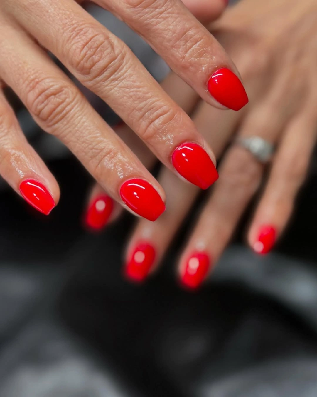 Short glossy red coffin nails in a vivid solid shade