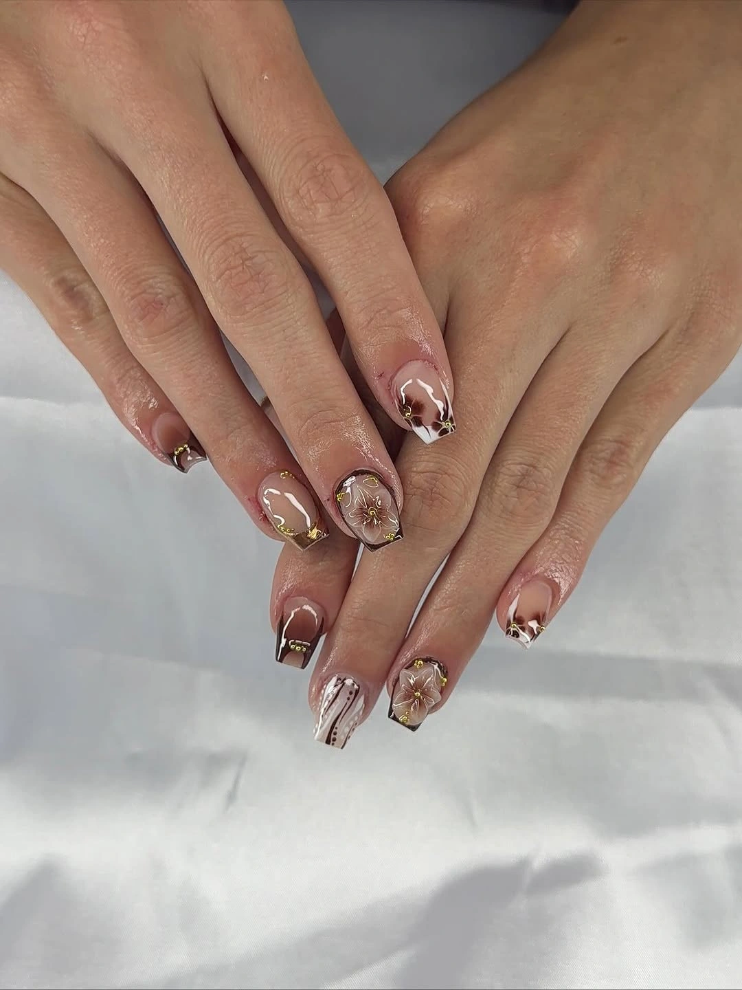 Short nude coffin nails with delicate warm metallic accents