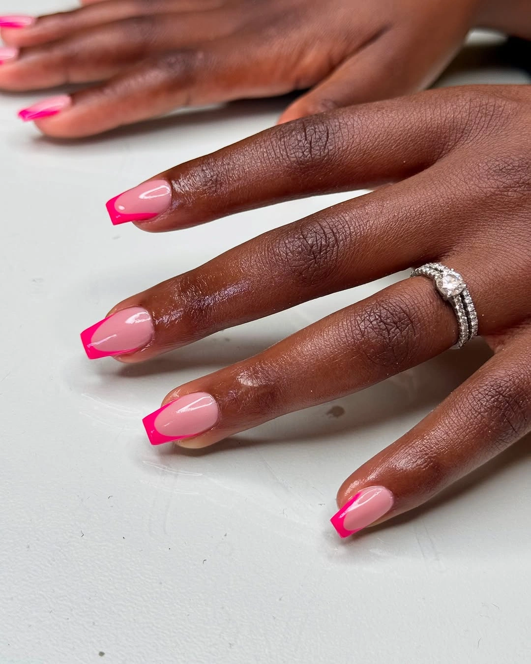 Short sheer pink coffin nails with vivid hot pink French tips