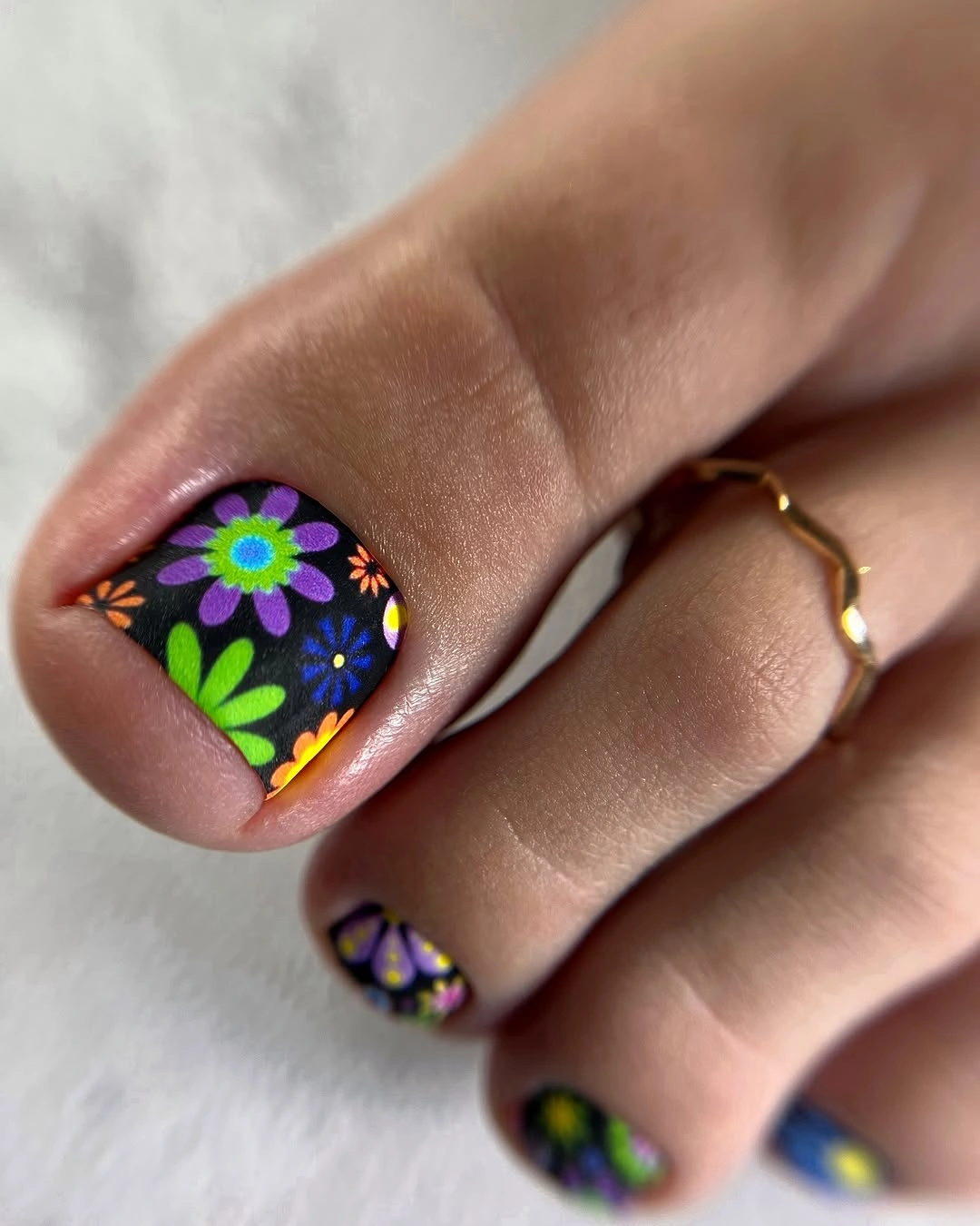 Dark square toes with purple flowers and green leaves on the big toe