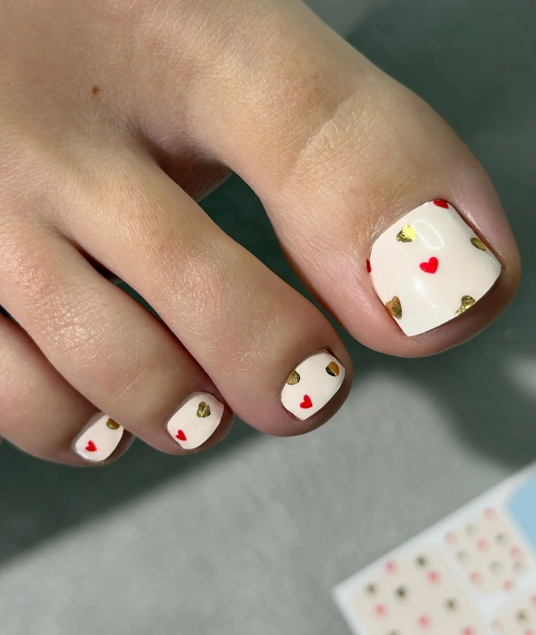 Short square creamy white toes with small red and green accents