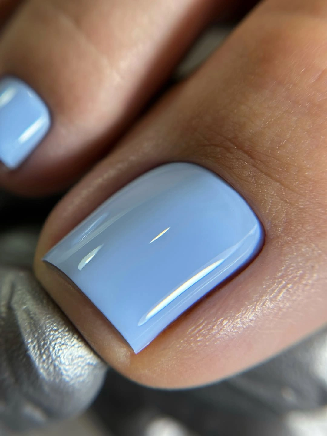 Close-up of one short square toe in glossy pale blue