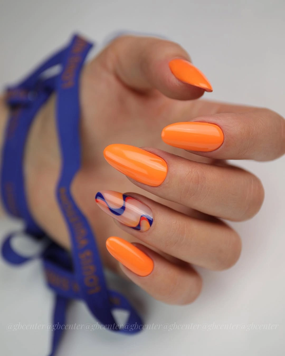 Medium square orange nails with blue and white curved details