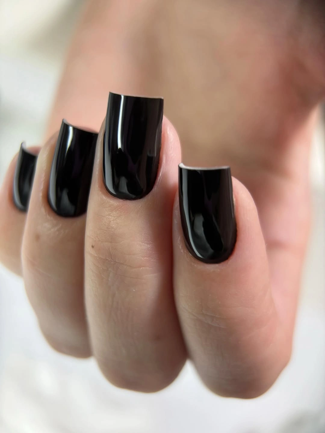 Long glossy black square nails with a solid reflective finish