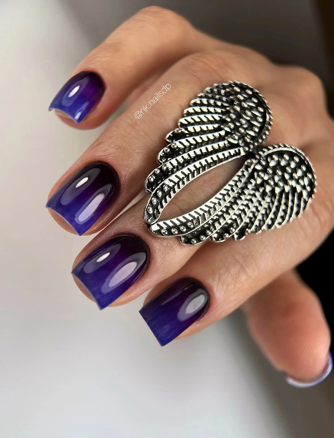 Medium-long glossy indigo-purple square nails with translucent depth