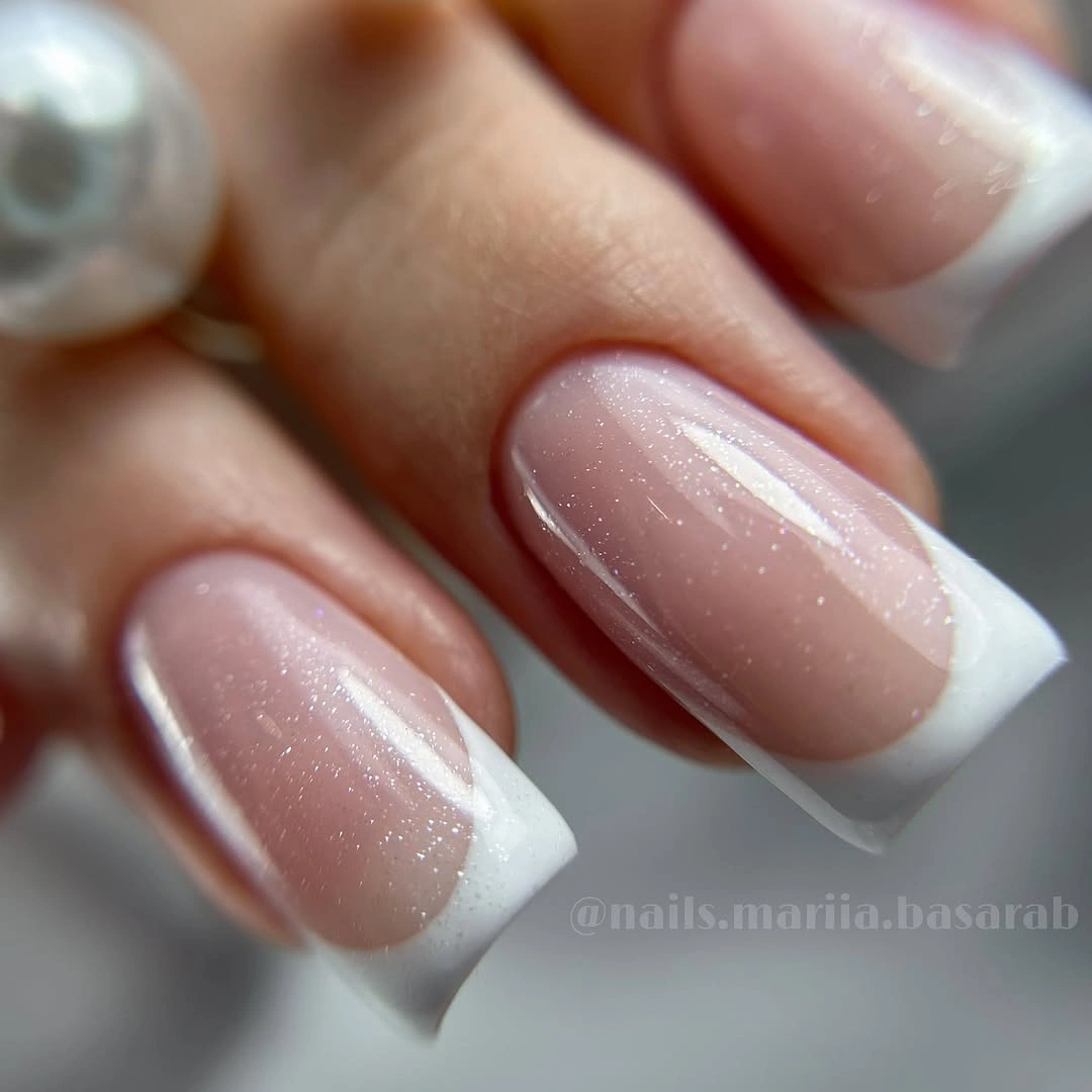 Angled white French tips with sheer sparkle