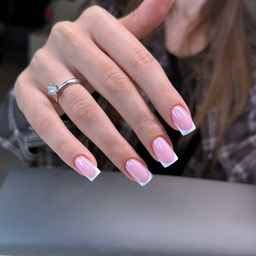 Crisp pink and white French nails at moderate length