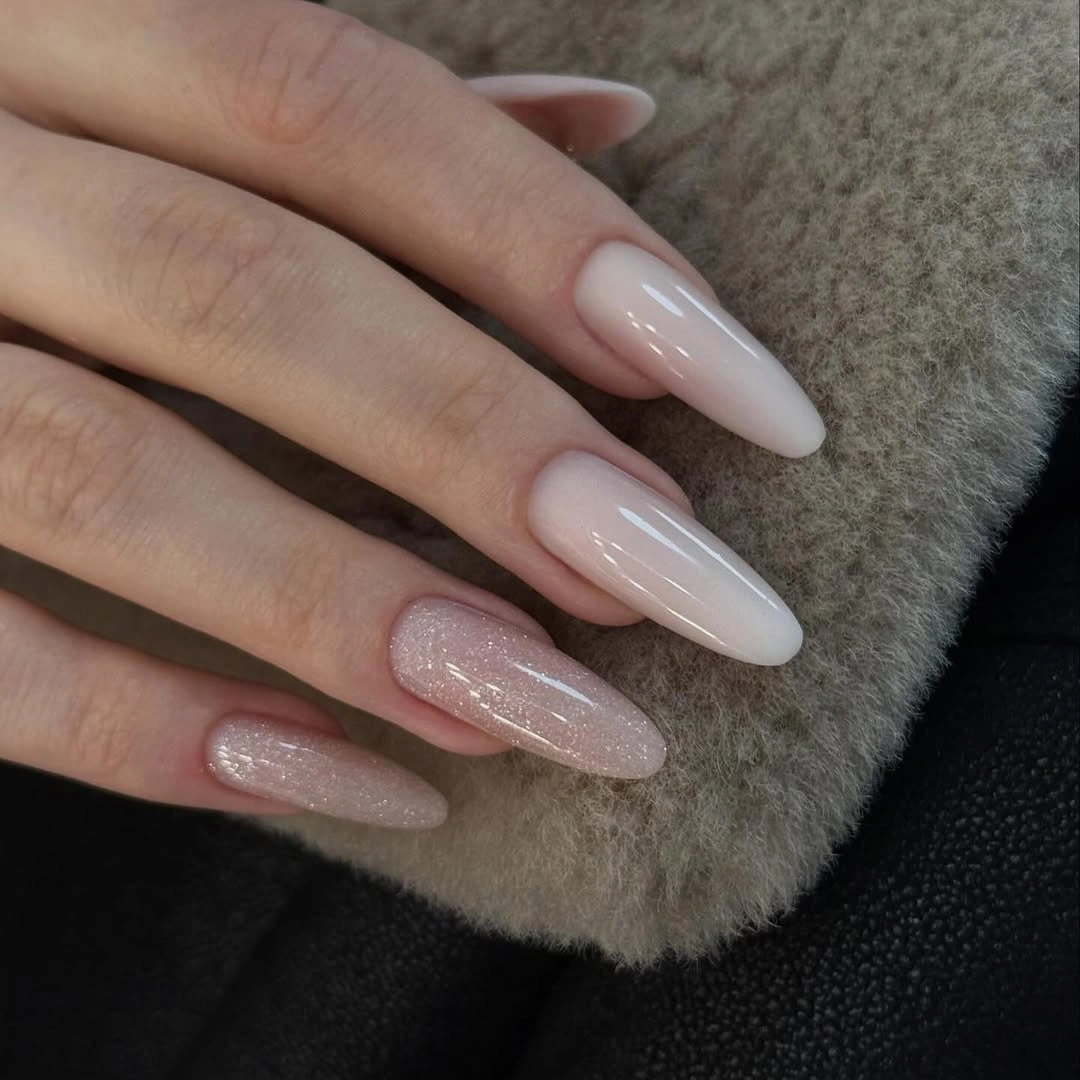 Milky nude nails with pale pink glitter accents
