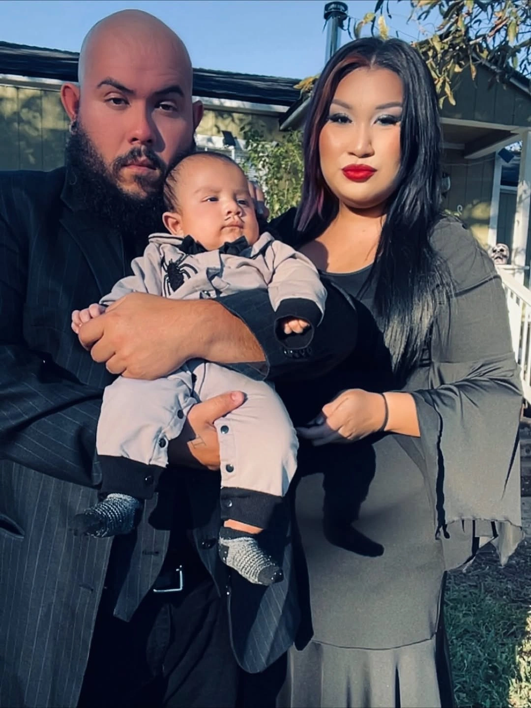 Family costumes with dark adult layers and pale baby outfit