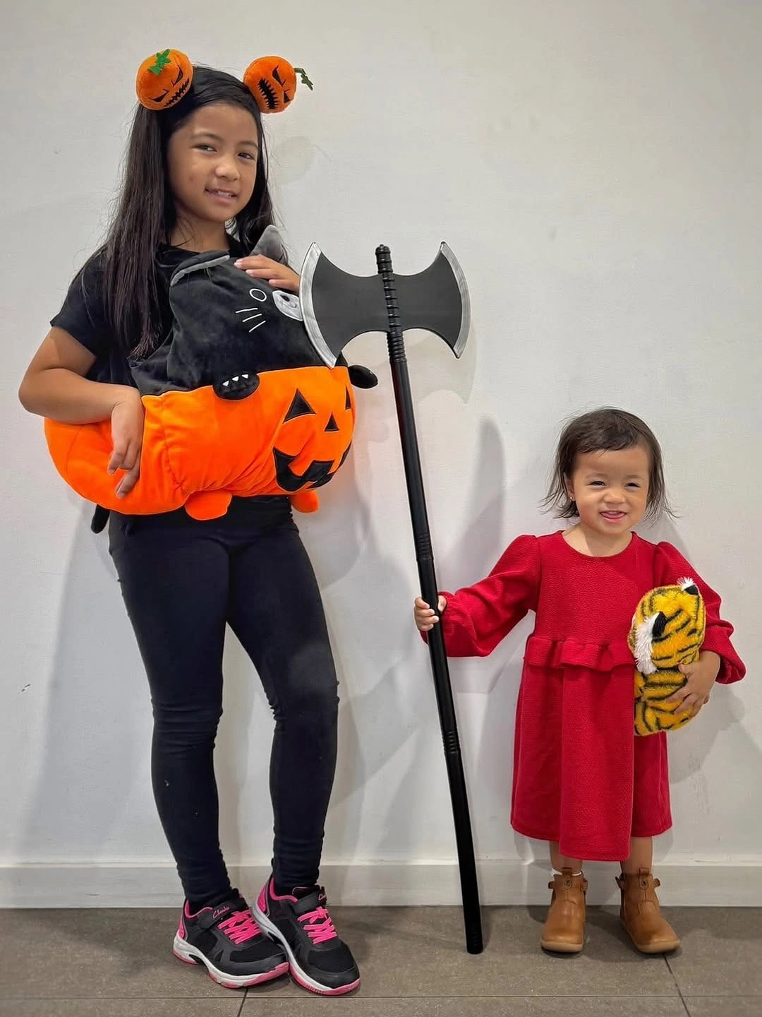Girl Halloween costume with black pumpkin pillow red dress and toy prop