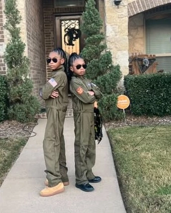 Girls Halloween costumes in olive jumpsuits dark eyewear and boots