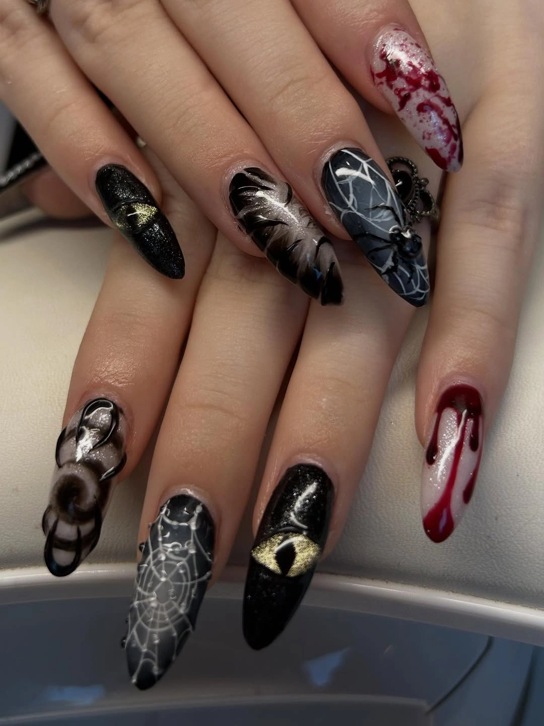 Long pointed nails with black silver webs and red accents