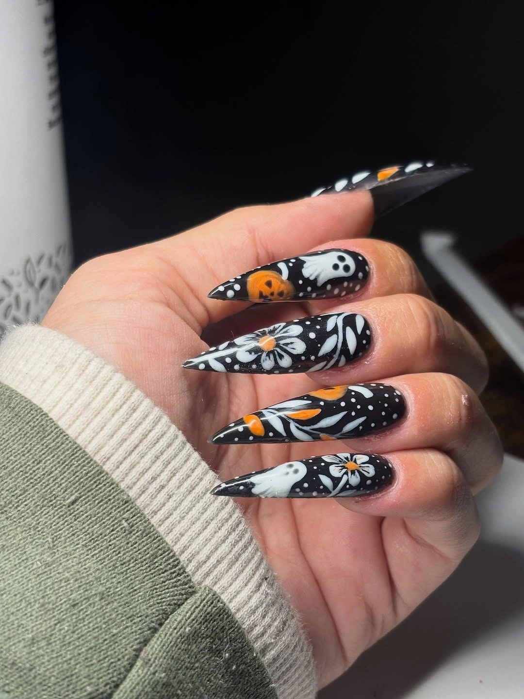 Very long black coffin nails with white line art and pumpkins