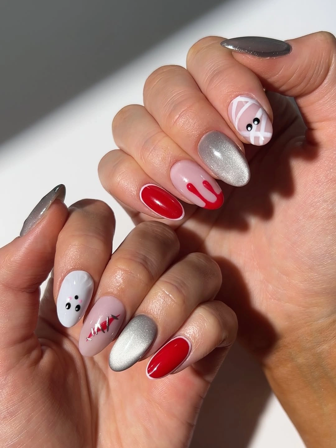 Medium almond nails with nude red silver ghosts and curves