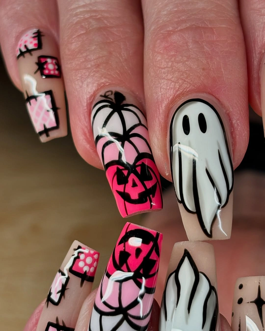 Long pink coffin nails with outlined ghosts and pumpkins
