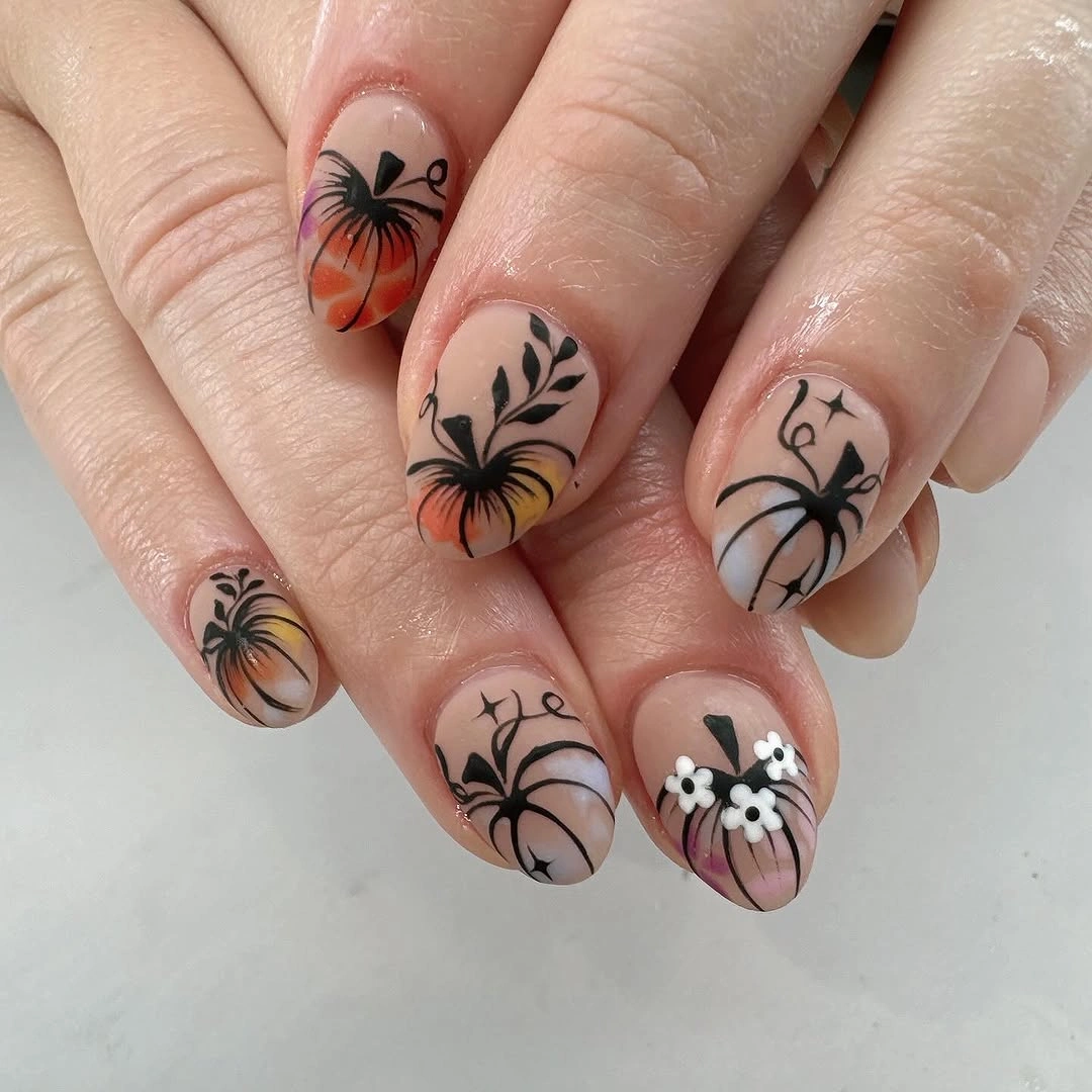 Short neutral nails with fine black spiderwebs, spiders, and muted orange details