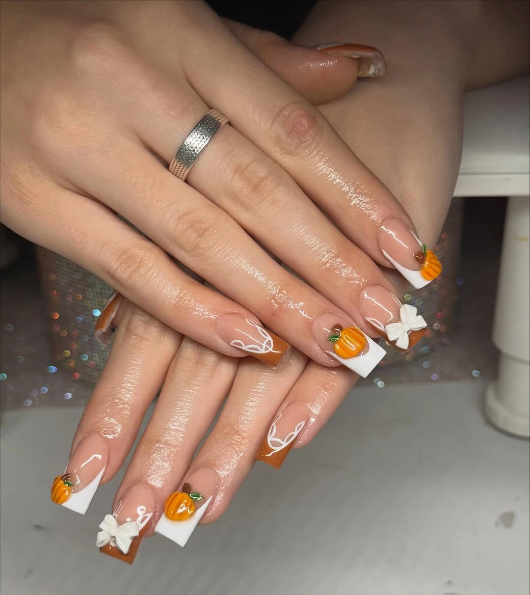 Long light square nails with white tips, small pumpkin, ghost, and black line details