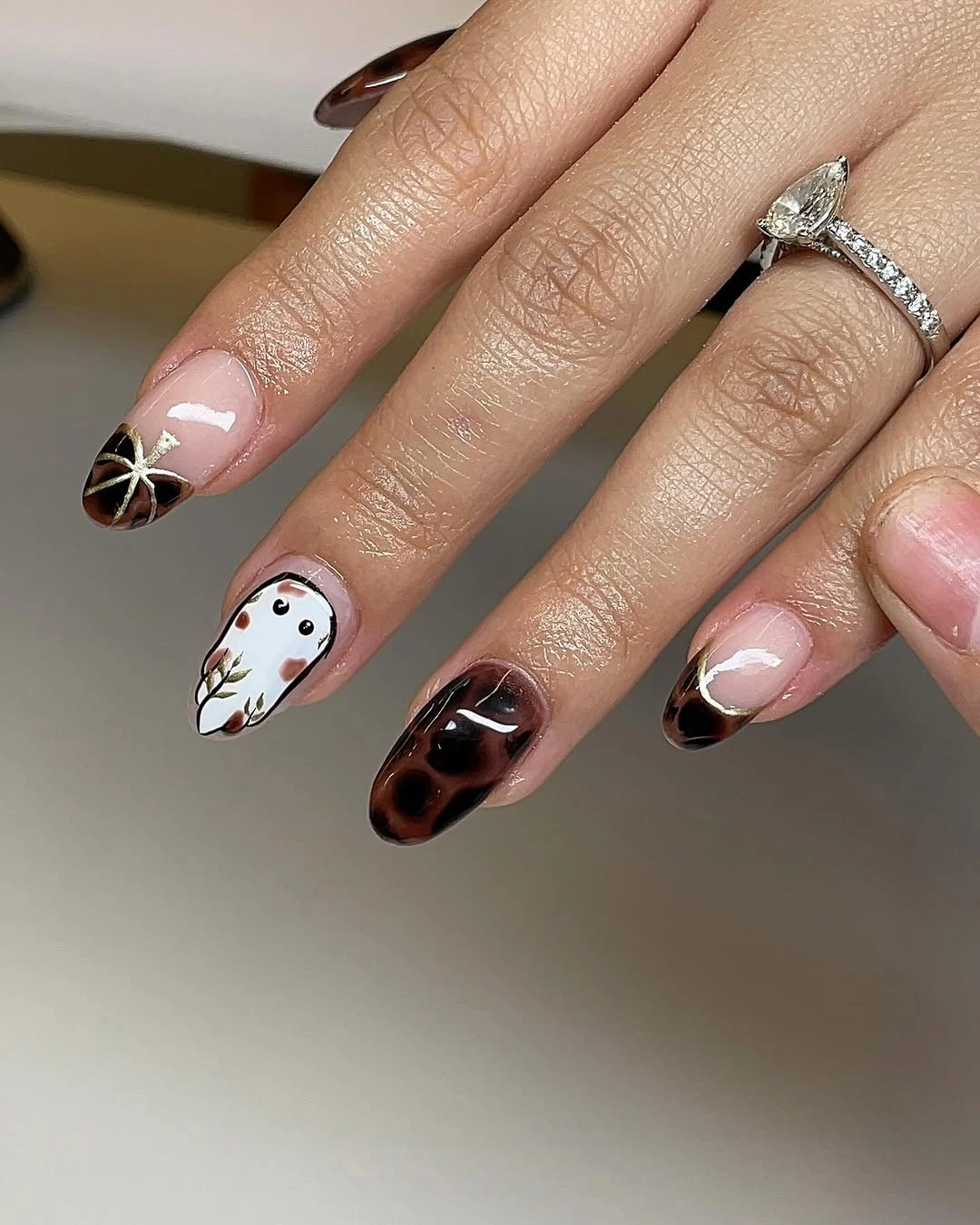 Sheer pink almond nails with dark curved tips and white ghost accents