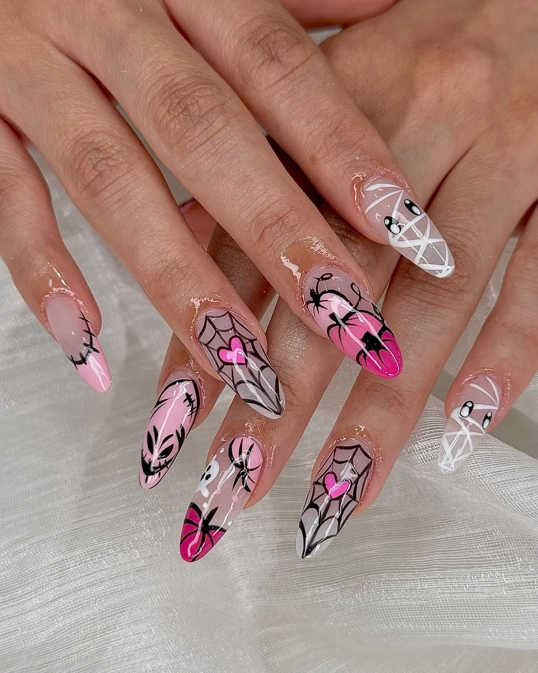 Extra-long sheer pink coffin nails with black spiderwebs and vivid pink bows