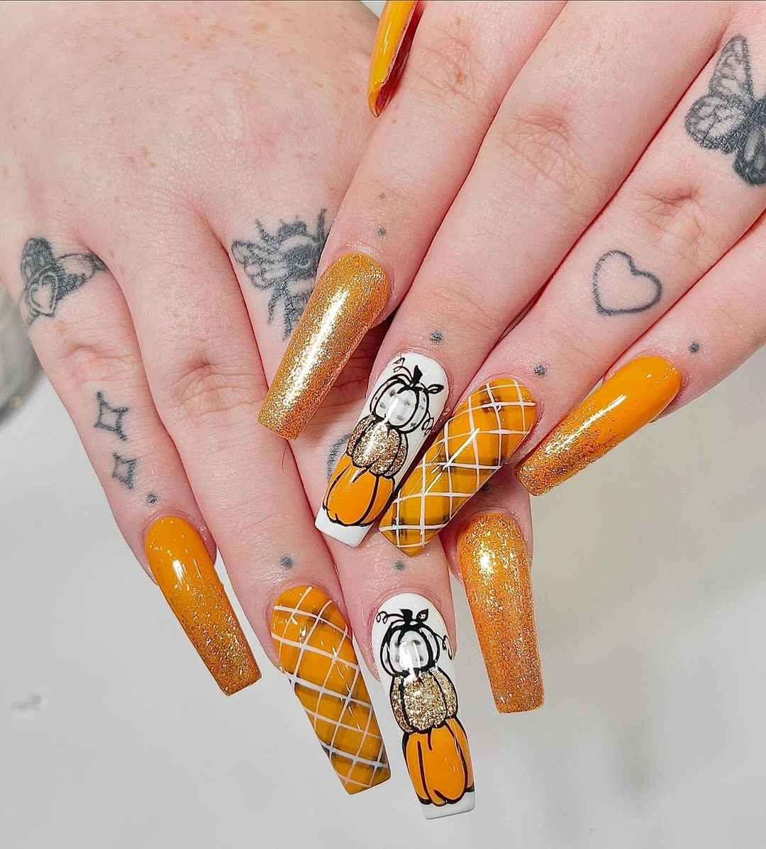 Long orange and gold coffin nails with plaid grid and pumpkin art
