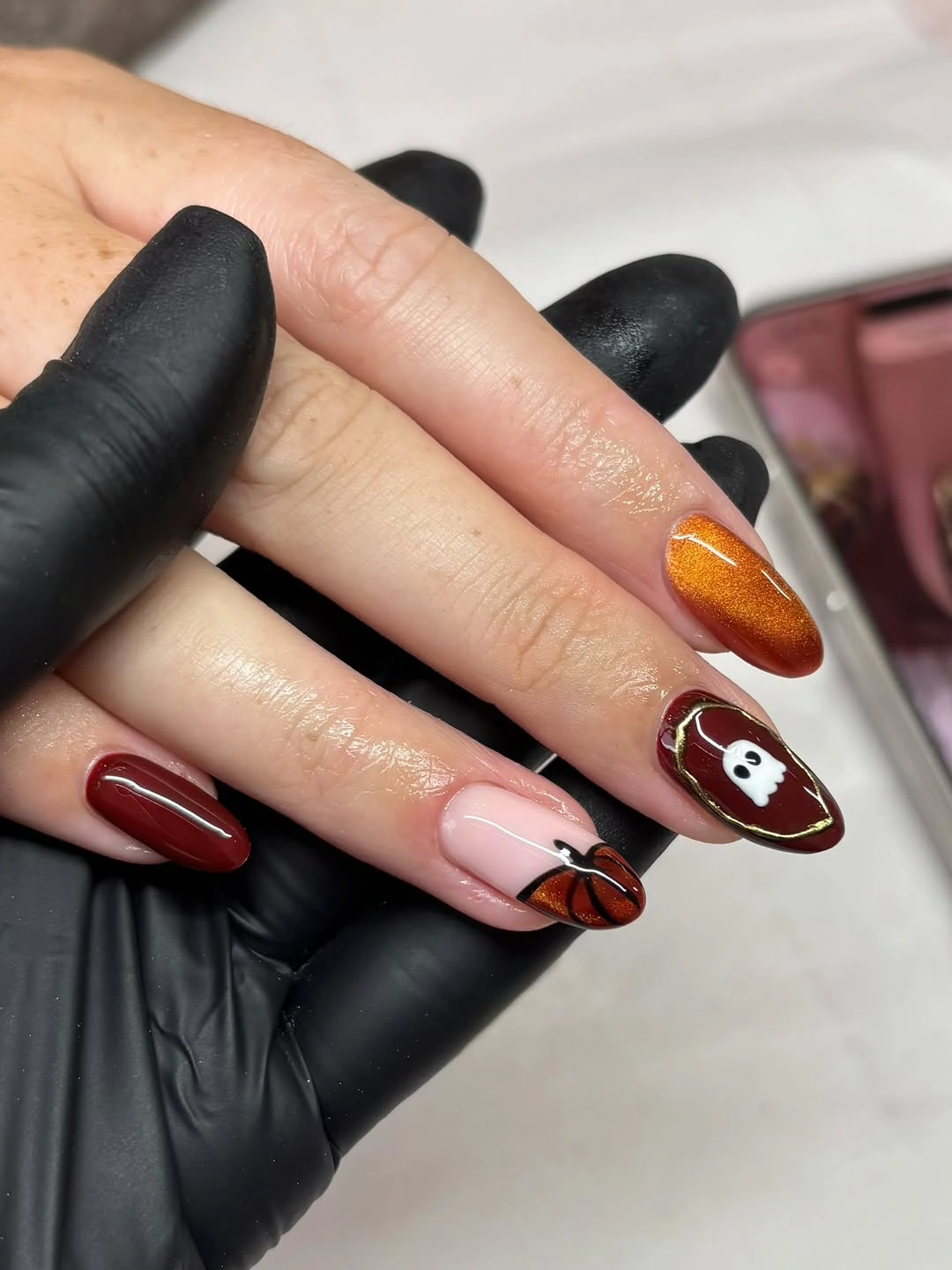 Short rounded nails with burgundy orange pink Halloween icons