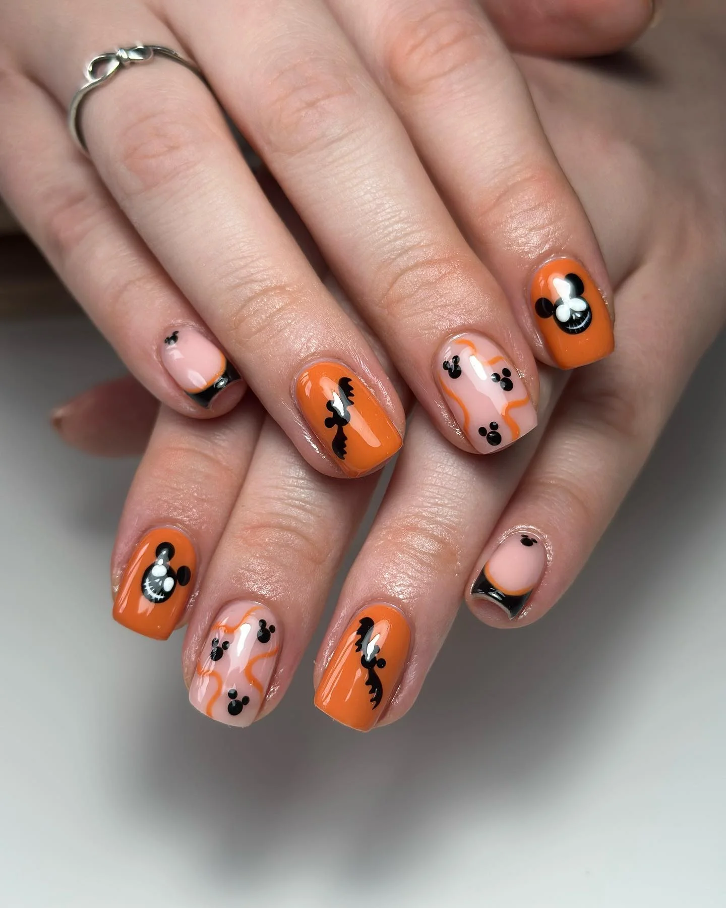 Short bright orange nails with black bats and tiny faces