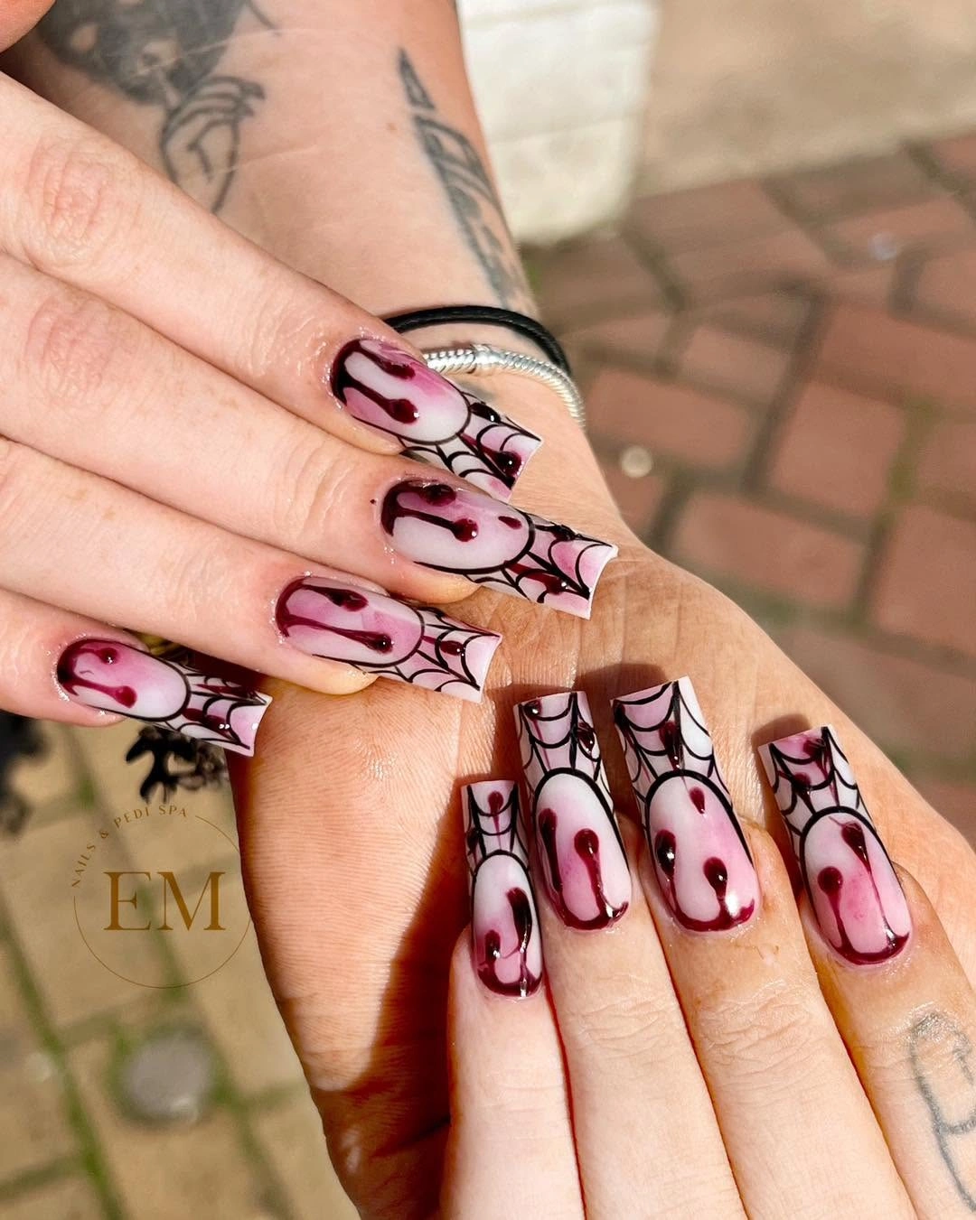 Long pink coffin nails with black outlines and red drip art