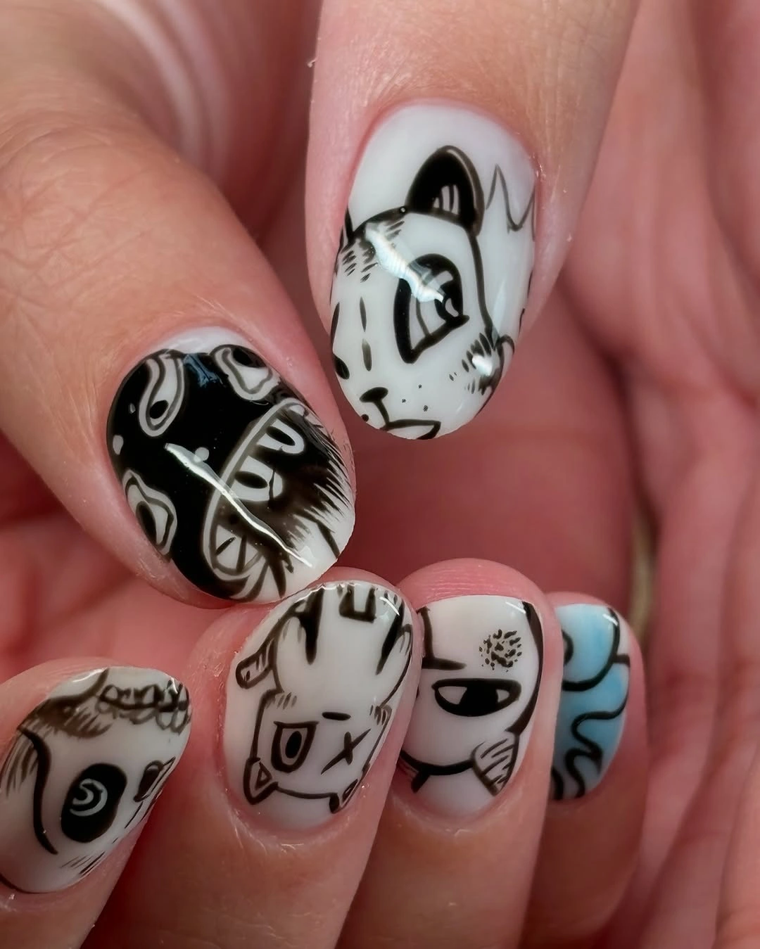 Short black white nails with abstract faces and blue accent