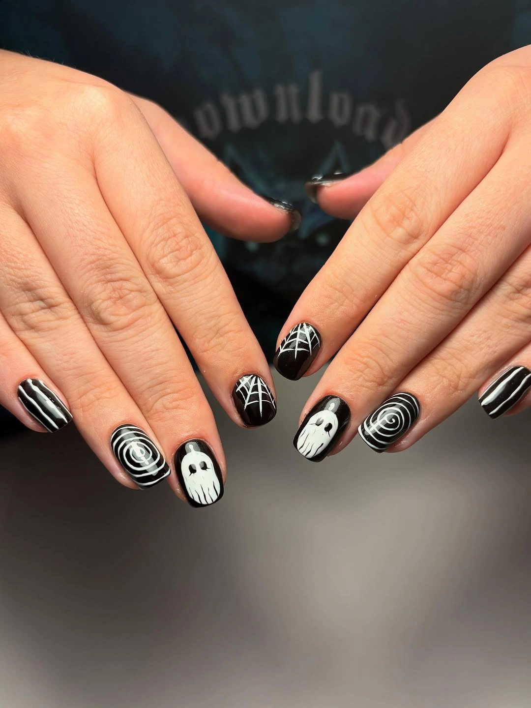 Rounded black and white nails with spirals and ghost accents
