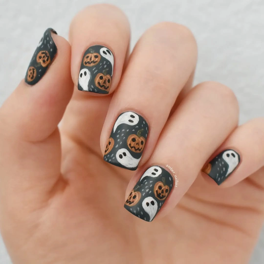 Short taupe nails with repeated black white Halloween faces